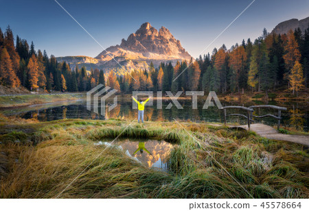 Man with raised up arms on Antorno lake 45578664
