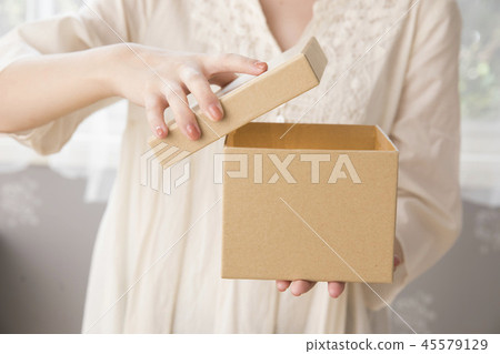 A woman who opens a box A woman who opens a box 45579129