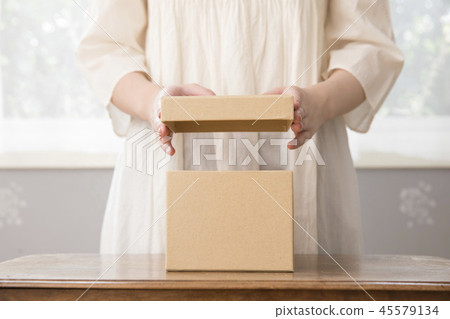 A woman who opens a box A woman who opens a box 45579134