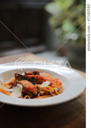 Penne pasta tomato sauce arabiata with seafood on wood background vintage style 45580588