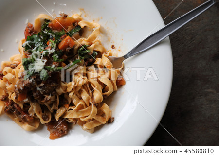 Pasta Fettuccine Bolognese with beef and tomato sauce on wood background in dark tone mystic light style Pasta Fettuccine Bolognese with beef and tomato sauce on wood background in dark tone mystic light style 45580810