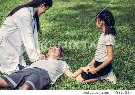 Doctor helping fainted senior man on the ground. 45581823