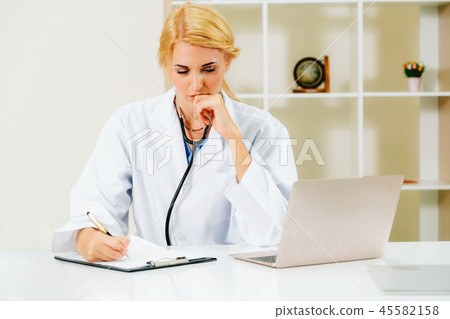 Serious doctor working in hospital office. Serious doctor working in hospital office. 45582158