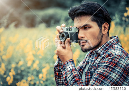 Young hipster man taking photo with retro camera. 45582510