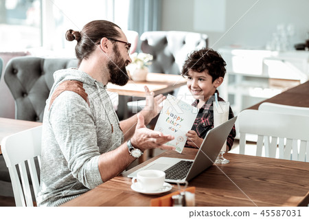 Cute curly dark-haired son congratulating his father with fathers day 45587031