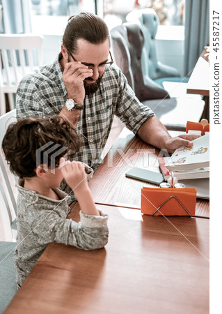 Father and son feeling involved in reading interesting kids book 45587217