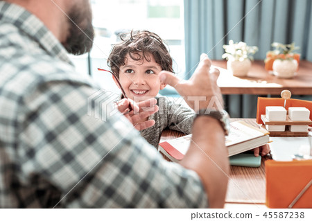 Funny dark-haired preschooler listening to his private tutor 45587238