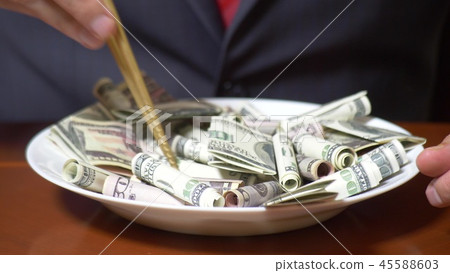 Hands of a businessman with chopsticks and dollar rolls. eating dollars. Hands of a businessman with chopsticks and dollar rolls. eating dollars. 45588603