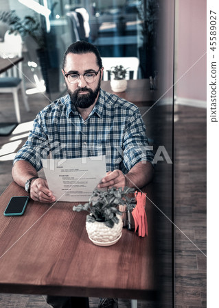 Successful businessman looking at the menu coming to cafeteria Successful businessman looking at the menu coming to cafeteria 45589027