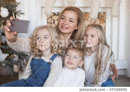 Mom with kids making selfie on the background of the Christmas tree. Mom with kids making selfie on the background of the Christmas tree. 45589890
