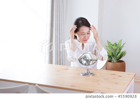 A middle woman watching a mirror 45590928