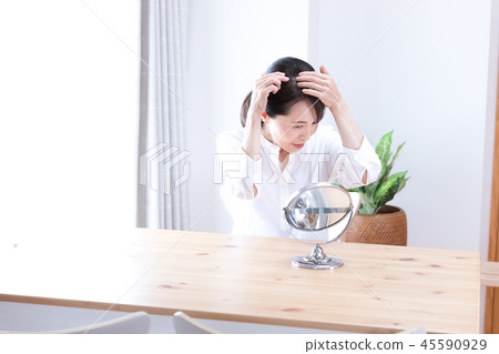 A middle woman watching a mirror 45590929