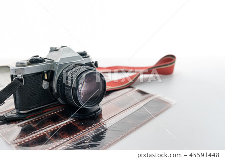 Retro camera with red strap on film negative roll Retro camera with red strap on film negative roll 45591448