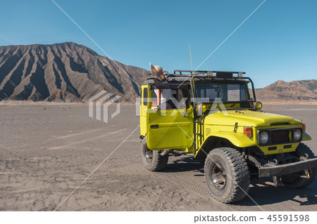 Tourist woman standing on door yellow four wheel 45591598