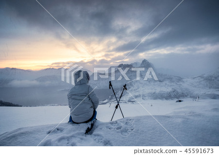 Mountaineer sitting with trekking pole 45591673