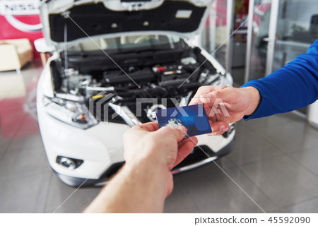 Hands of car mechanic with wrench in garage, payment by credit card 45592090