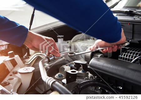 Hands of car mechanic with wrench in garage. Hands of car mechanic with wrench in garage. 45592126
