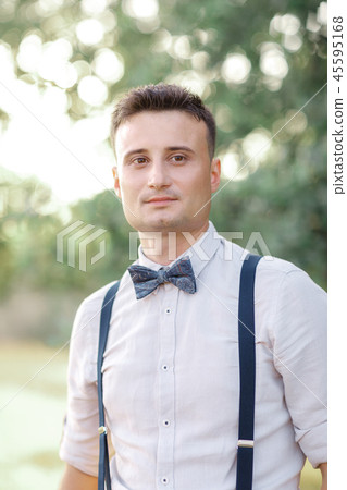 Portrait of a young handsome groom outdoors. 45595168