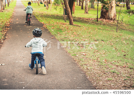Kids riding their bicycles along track Kids riding their bicycles along track 45596500