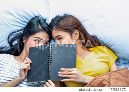 Cute Asian lesbian couple reading book together 45598575