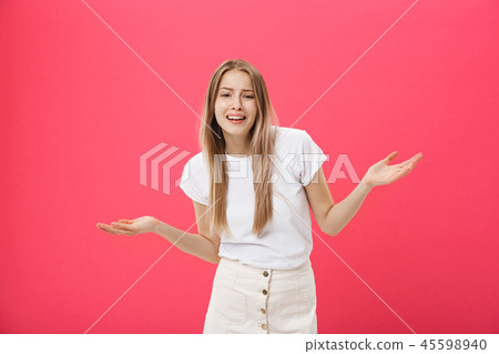 Displeased female model with freckled skin, raises eyebrows and frowns face, makes refusal gesture 45598940