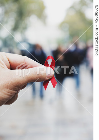 man with a red ribbon for the fight against AIDS 45600079