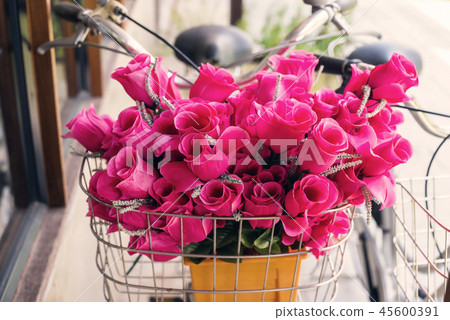 Pink flowers on front bicycle basket Pink flowers on front bicycle basket 45600391