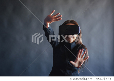 Happy woman on a black background in the studio gets the experience of using VR-glasses virtual Happy woman on a black background in the studio gets the experience of using VR-glasses virtual 45601583