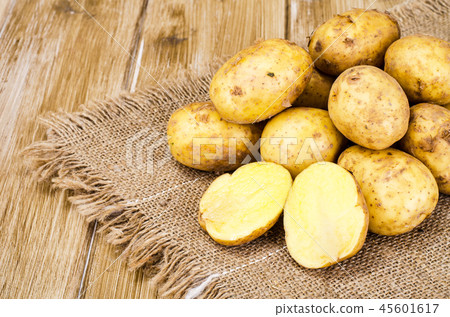 Fresh raw potatoes on wooden surface Fresh raw potatoes on wooden surface 45601617