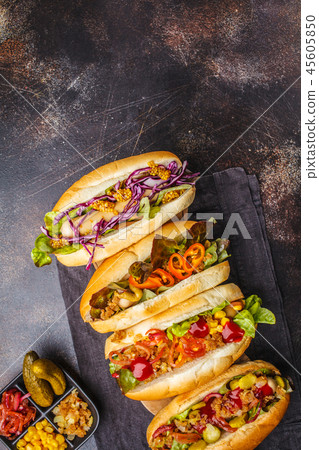 Hot dogs with assorted toppings on a dark  45605850