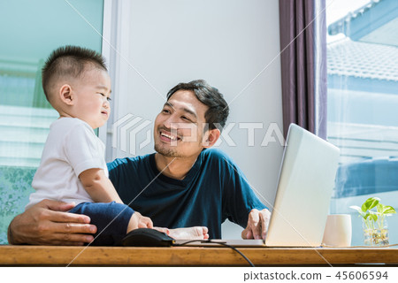 Single dad and son using laptop together happily 45606594