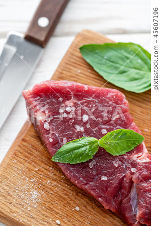 Raw meat with marinated salt, pepper and Basil seasoning leaf. Morning in the kitchen. Raw fresh 45607196