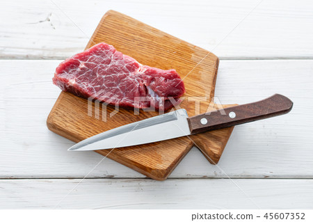 Raw meat. Raw fresh beef steak on a wood cutting board and Carving knife. White wooden background 45607352