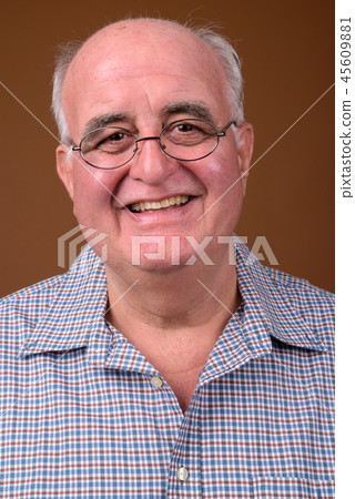 Overweight senior man wearing eyeglasses against brown backgroun Overweight senior man wearing eyeglasses against brown backgroun 45609881
