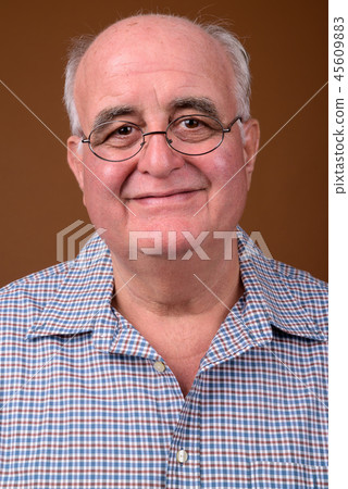 Overweight senior man wearing eyeglasses against brown backgroun Overweight senior man wearing eyeglasses against brown backgroun 45609883