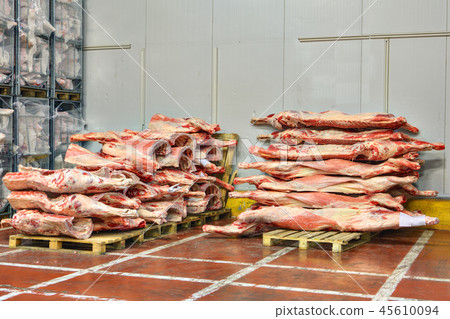 Frozen beef carcasses are stacked on pallets 45610094