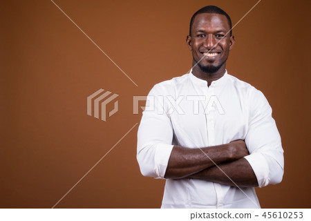 Portrait of handsome African businessman against brown background Portrait of handsome African businessman against brown background 45610253