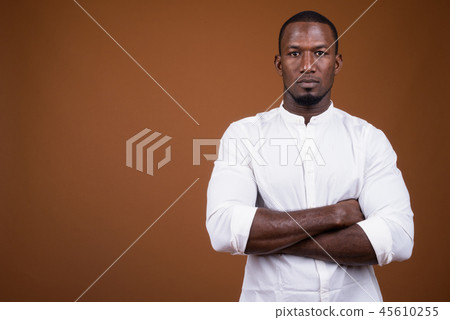 Portrait of handsome African businessman against brown background Portrait of handsome African businessman against brown background 45610255