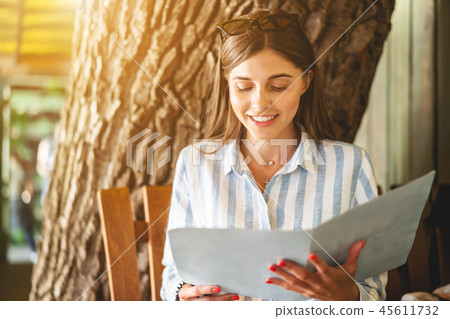 Beautiful tourist woman in restaurant watching the menu 45611732