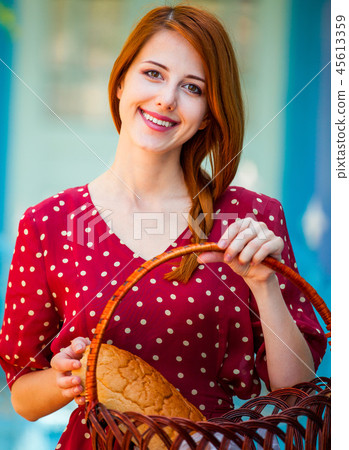 girl in red dress with basket near old blue color house girl in red dress with basket near old blue color house 45613359