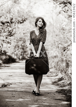 girl with travel suitcase staying on rural road girl with travel suitcase staying on rural road 45613422