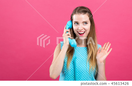 Young woman talking on old fashioned phone Young woman talking on old fashioned phone 45613426