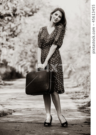 girl with travel suitcase staying on rural road girl with travel suitcase staying on rural road 45613455