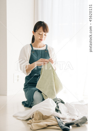 Housewife in her 30s folding laundry Housewife in her 30s folding laundry 45620131
