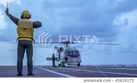 Signal man give a signal to helicopter on the deck Signal man give a signal to helicopter on the deck 45620173