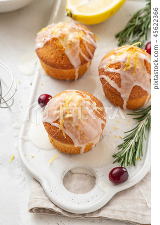 Muffins, cakes with cranberry and lemon on a white board. 45622366