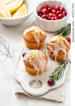 Muffins, cakes with cranberry and lemon on a white board. 45622368