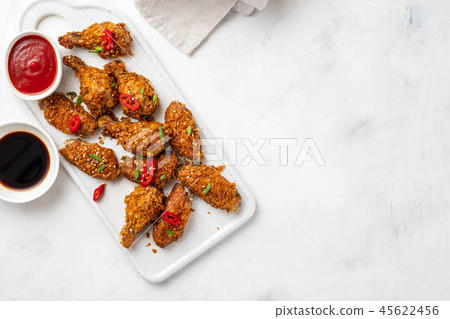 Chicken nuggets with sauce and pepper on a white board. Copy space. Chicken nuggets with sauce and pepper on a white board. Copy space. 45622456