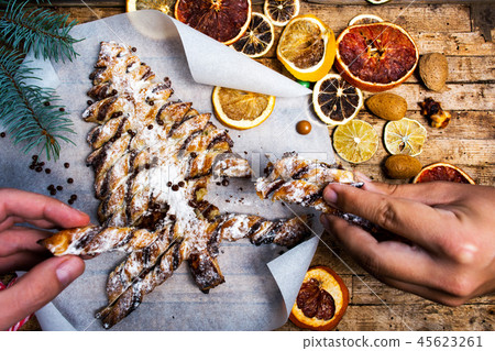Hands grabbing christmas tree pastry dessert Hands grabbing christmas tree pastry dessert 45623261