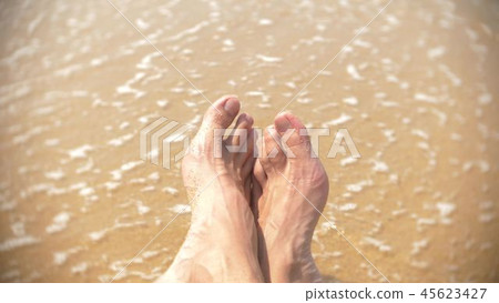 men's legs on the beach on the background of a wave of 45623427